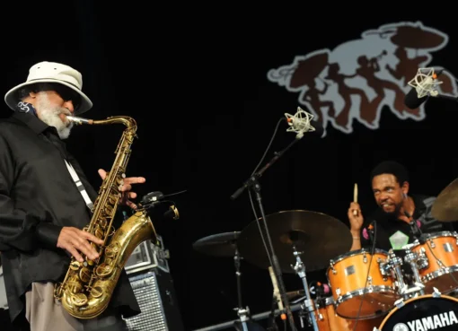 A black and white photo of Sonny Rollins playing his tenor saxophone.