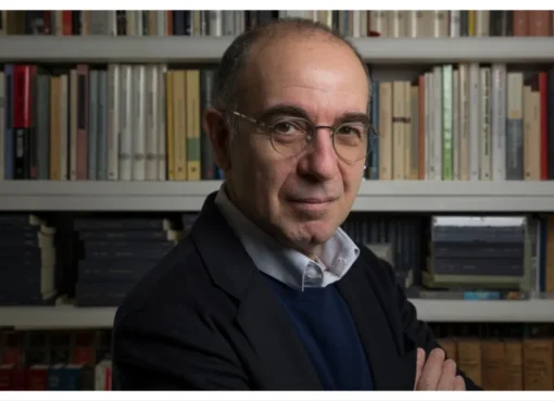 Giuseppe Tornatore receiving an award at the Taormina Film Festival in an ancient open-air theater.