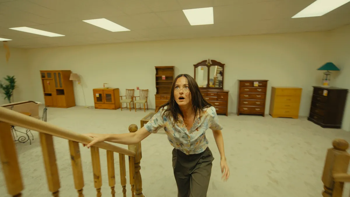 A movie poster for 'Backrooms' showing a person in a yellow, eerie, empty hallway.