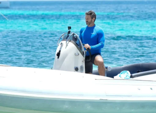 A yacht sailing on a bright blue ocean.