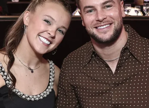 JoJo Siwa smiling brightly with Chris Hughes next to her, likely from Celebrity Big Brother UK.