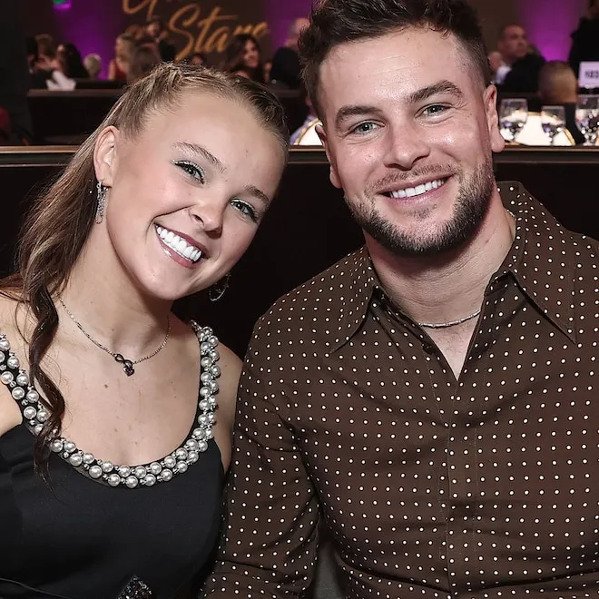 JoJo Siwa smiling brightly with Chris Hughes next to her, likely from Celebrity Big Brother UK.