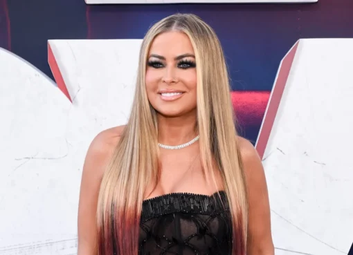 Carmen Electra smiling brightly on a red carpet.