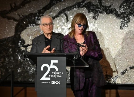 Robert De Niro speaking passionately into a microphone on stage, with a serious expression at the Tribeca Festival.