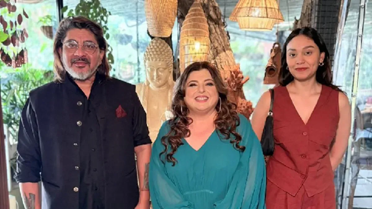 Delnaaz Irani smiling in a kitchen setting, next to Rajan Shahi and Ishika Shahi.