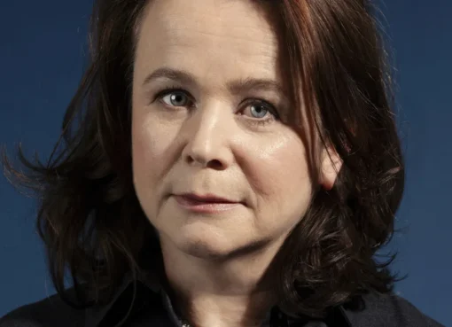 British actress Emily Watson smiling, holding what looks like a prestigious award or attending a film festival.