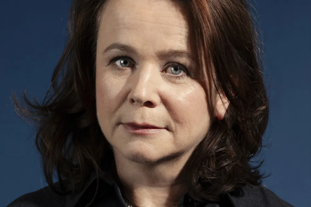British actress Emily Watson smiling, holding what looks like a prestigious award or attending a film festival.