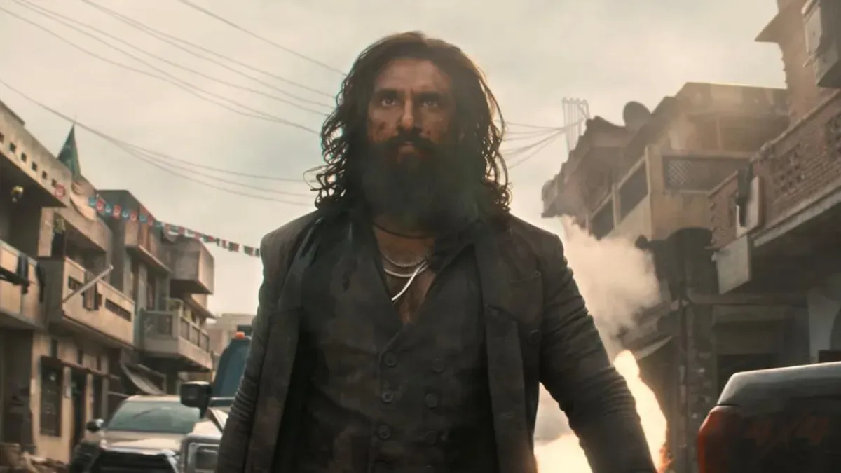 A dramatic movie poster for Dhurandhar 2 with intense colors and lead characters.