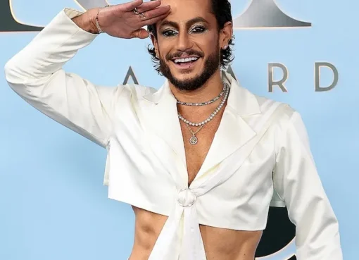 Frankie Grande smiling proudly, perhaps looking at a screen showing Ariana Grande.