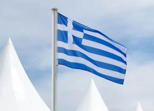 A vibrant photo of the Greek flag waving, perhaps with a film reel overlay or Cannes festival background.