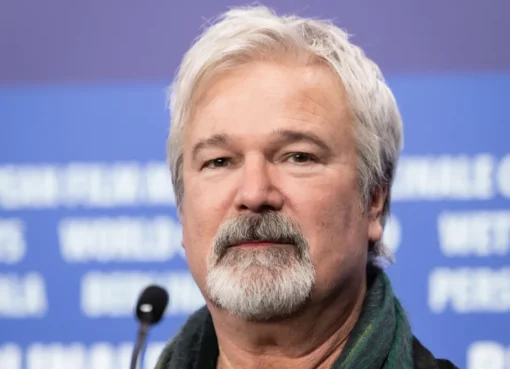 Gore Verbinski speaking at a film festival, looking serious but engaged.
