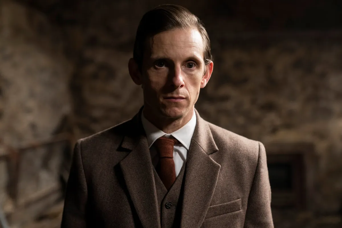 Jamie Bell looking thoughtful and smiling slightly.