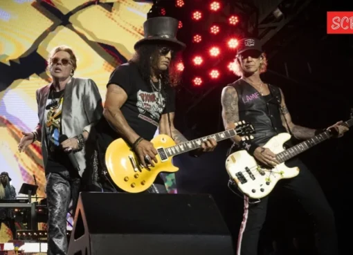Guns N' Roses band members performing on stage with vibrant lighting.