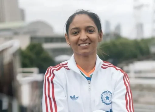 Harmanpreet Kaur, looking serious and focused, stands in her Indian cricket uniform.
