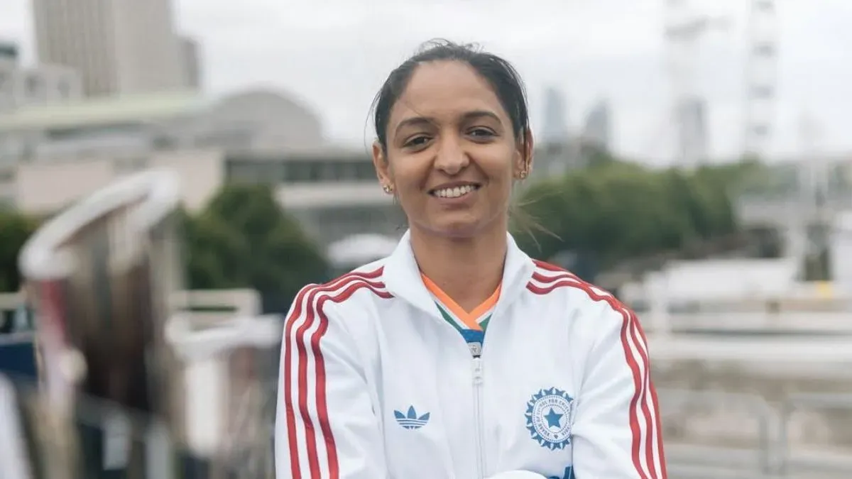 Harmanpreet Kaur, looking serious and focused, stands in her Indian cricket uniform.