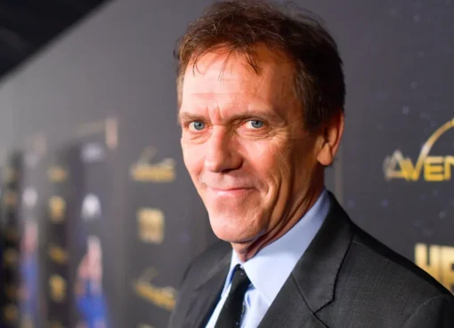 Hugh Laurie looking thoughtful with a slight grin.