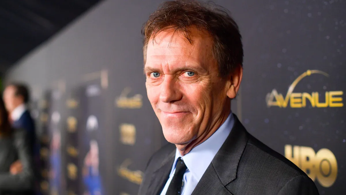Hugh Laurie looking thoughtful with a slight grin.