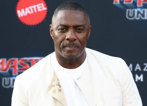 Idris Elba looking serious in a suit.