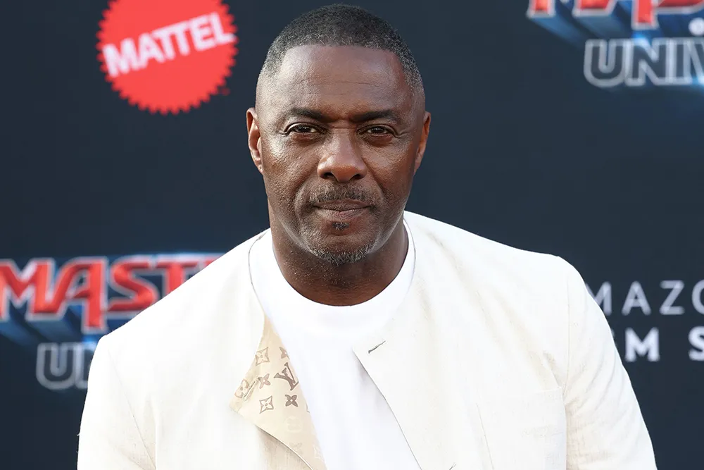 Idris Elba looking serious in a suit.