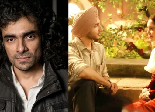 Director Imtiaz Ali smiling and waving to a crowd of fans inside a cinema hall.