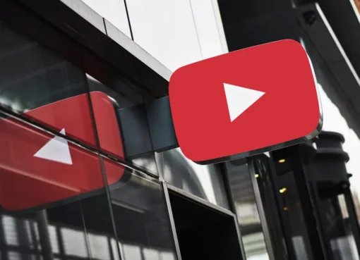 A smartphone screen displaying the YouTube logo, with blurred images of news headlines and baseball game clips in the background.