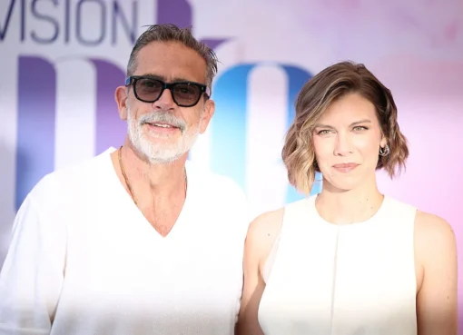 Jeffrey Dean Morgan and Lauren Cohan share a laugh on a red carpet at a festival.