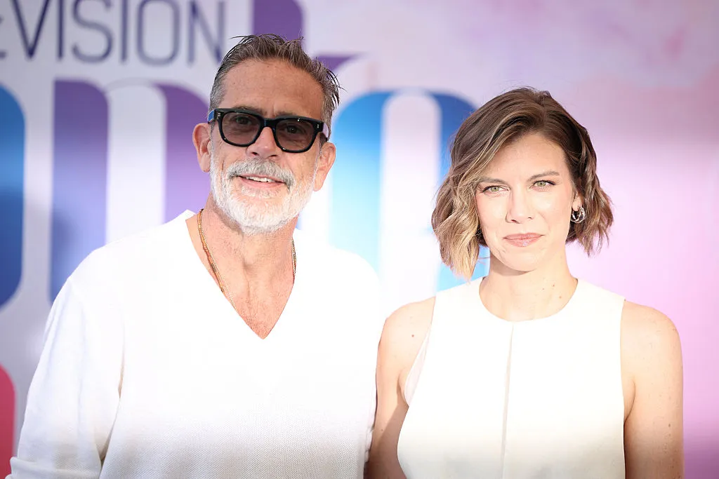 Jeffrey Dean Morgan and Lauren Cohan share a laugh on a red carpet at a festival.