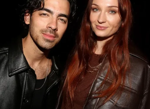Joe Jonas smiling with his two young daughters.