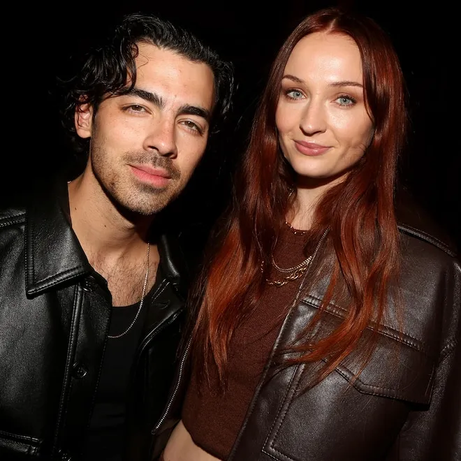 Joe Jonas smiling with his two young daughters.