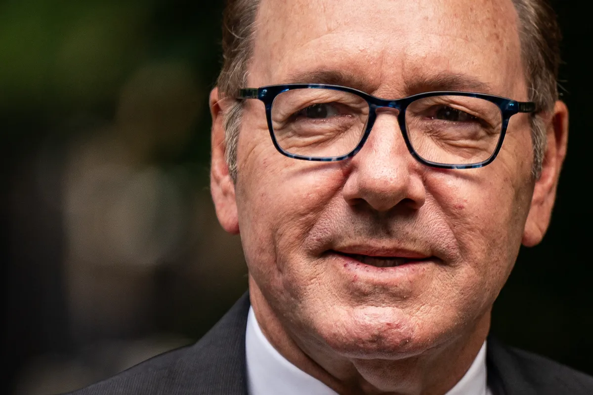 Kevin Spacey talking during a podcast interview with warm lighting