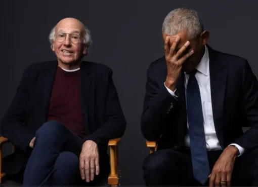 Larry David in historical costume on a TV show set.