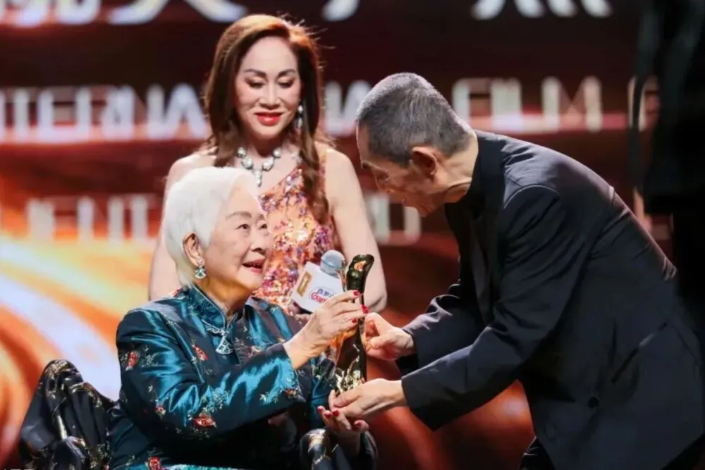 Lisa Lu smiling on stage at a film festival event.
