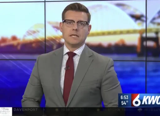 A news anchor looking emotional on TV.