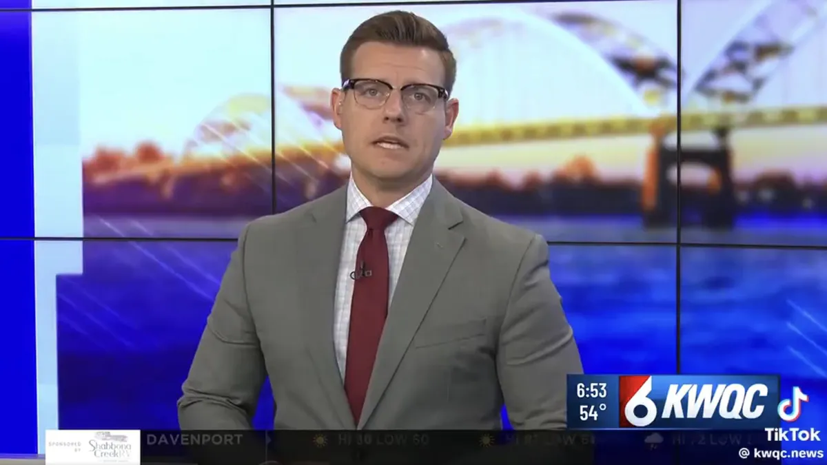 A news anchor looking emotional on TV.