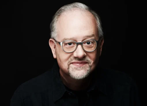 A headshot of playwright and screenwriter Doug Wright smiling slightly.