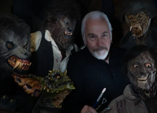 Legendary make-up artist Rick Baker, looking thoughtful, likely surrounded by his creative work.