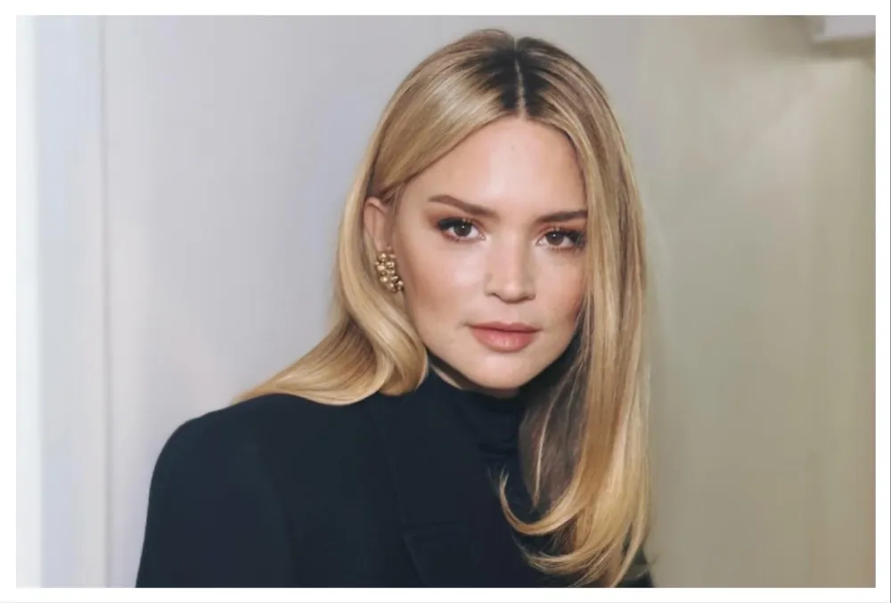 Virginie Efira smiling at a film festival, looking elegant and happy.