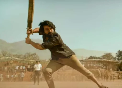 Ram Charan and Janhvi Kapoor looking serious in a vibrant scene from their movie Peddi.