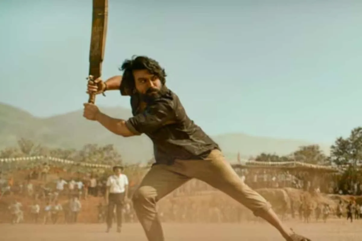 Ram Charan and Janhvi Kapoor looking serious in a vibrant scene from their movie Peddi.