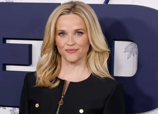 Reese Witherspoon smiling in a bright pink suit