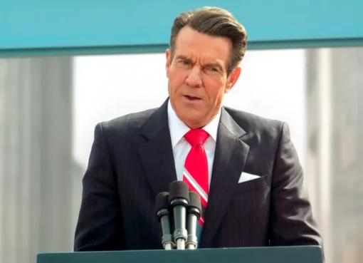Dennis Quaid as Ronald Reagan looking presidential in a sharp suit.