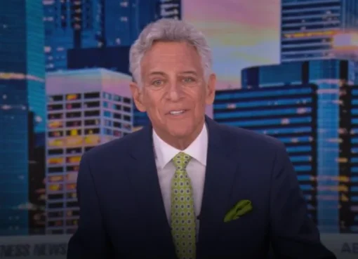 Photo of Bill Ritter smiling on a news set.