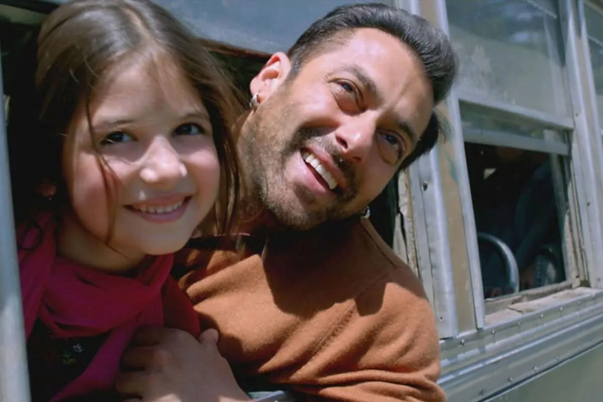 Salman Khan smiling kindly with Harshaali Malhotra on the set of Bajrangi Bhaijaan, both looking happy.