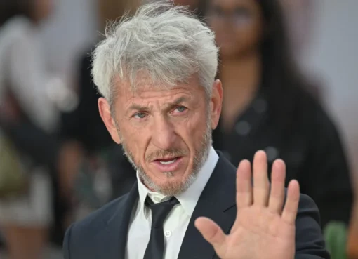 Sean Penn looking serious and intense, possibly avoiding a crowd or a phone camera.