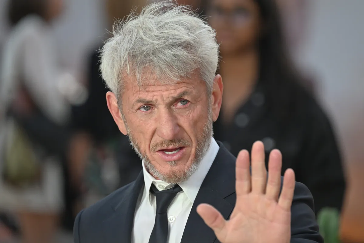Sean Penn looking serious and intense, possibly avoiding a crowd or a phone camera.