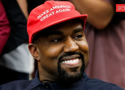 Kanye West standing on a stage with a moody spotlight