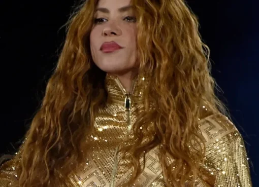 Shakira performing on stage with vibrant lighting.
