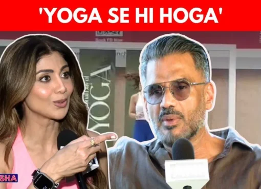 Shilpa Shetty in a yoga pose with Suniel Shetty looking on during an event celebrating International Yoga Day.