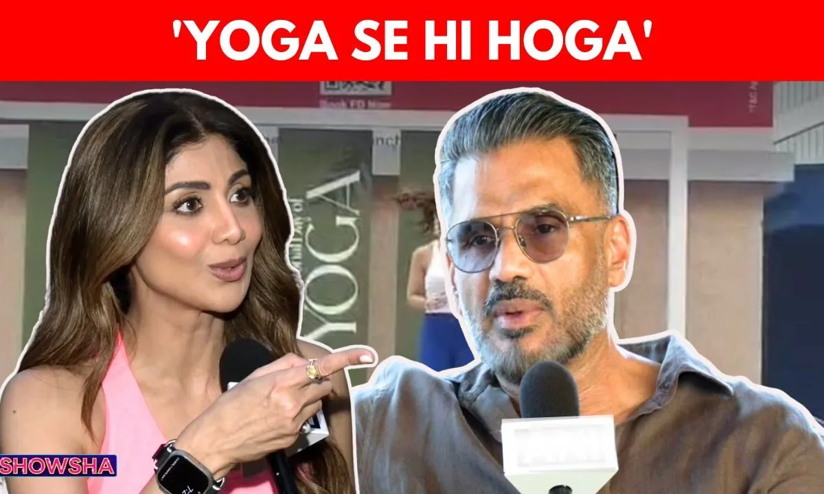 Shilpa Shetty in a yoga pose with Suniel Shetty looking on during an event celebrating International Yoga Day.