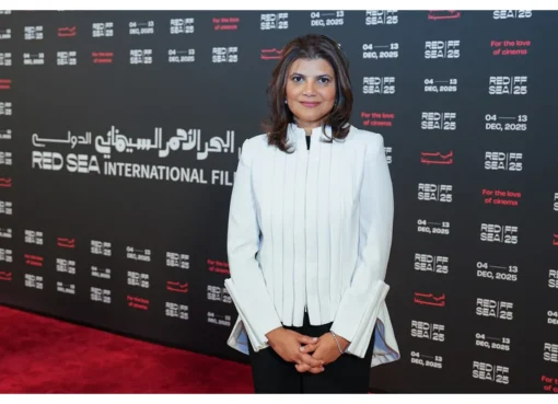 A professional-looking woman smiling brightly at a film festival event.